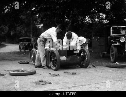 Mechaniker arbeiten an Leon Cushmans Austin 7 Racer für einen Geschwindigkeits-Weltrekord Versuch, Brooklands, 1931. Künstler: Bill Brunell. Stockfoto