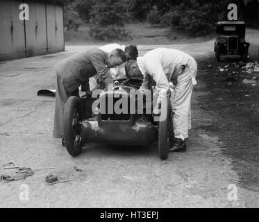 Mechaniker arbeiten an Leon Cushmans Austin 7 Racer für einen Geschwindigkeits-Weltrekord Versuch, Brooklands, 1931. Künstler: Bill Brunell. Stockfoto