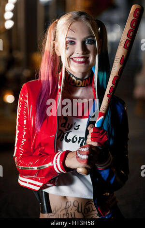 Porträt des Lächelns Cosplayer Mädchen in Tracht Harley Quinn auf Hintergrund Lichter der nächtlichen Stadt. Cosplay Stockfoto