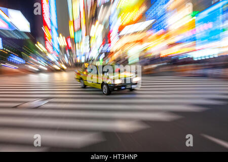 Tokio - 6. Juni 2015: Bewegung verwischt Taxi am Fußgängerüberweg Shibuya, Tokyo City, 6. Juni 2015 in Tokio, Japan. Stockfoto