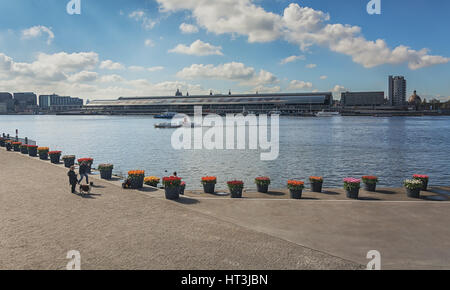 Amsterdam, Niederlande, 10. April 2016: Tulip Festival in Amsterdam entlang des Flusses IJ mit im Hintergrund Amsterdam Central Station. Stockfoto