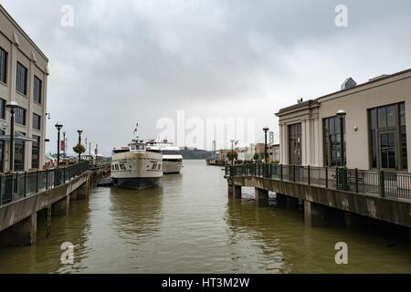 Boote auf einem Steg am Embarcadero, mit der Bay Bridge sichtbar in der Ferne, San Francisco, Kalifornien, 22. Januar 2017 mit der Fähre. Stockfoto