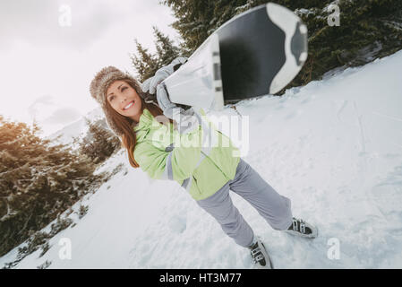 Schöne junge Frau im Ski-Urlaub genießen. Sie stehen mit den Skiern und wegschauen mit Lächeln. Stockfoto