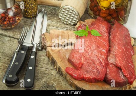 Vorbereitung zum Grillen. Rohes Rindfleisch auf einem Holzbrett. Hausaufgaben-steak Stockfoto