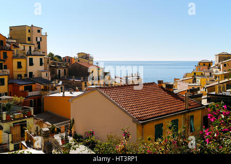 Eines der Cinque Terre Dörfer Riomaggiore, mit blauem Meer und Himmel im Hintergrund. Cinqueterre wurde 1997 zum UNESCO-Weltkulturerbe aufgenommen. Stockfoto