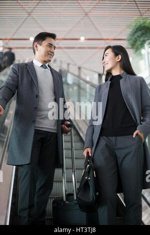 Geschäftsleute auf Rolltreppe im Flughafen Stockfoto