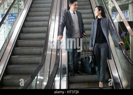 Geschäftsleute auf Rolltreppe im Flughafen Stockfoto