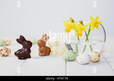 Schokolade Osterhasen, Narzissen in eine Vase und Schokolade Eiern Stockfoto