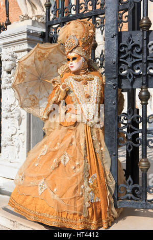 Eine maskierte Dame mit Regenschirm am Eingang des venezianischen Arsenal während der Karneval von Venedig, Italien Stockfoto