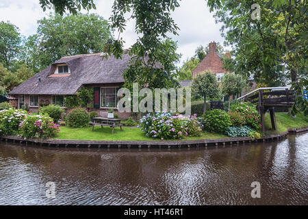 Giethoorn, Niederlande – 29. Juni 2016: Blick auf einen blühenden Garten vor dem Haus von der niederländischen Stadt. Stockfoto
