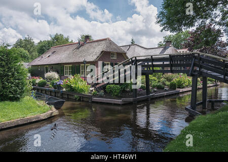 Giethoorn, Niederlande – 29. Juni 2016: Die Brücke führt über den Kanal in der niederländischen Stadt Giethoorn zu dem Haus. Stockfoto