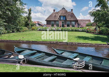 Giethoorn, Niederlande – 29. Juni 2016: Festgemachten Boote auf dem Kanal in den Hintergrund-Haus mit Garten. Stockfoto
