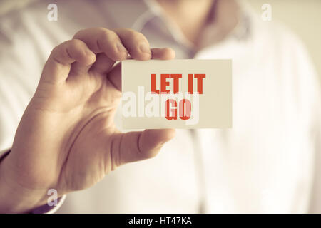 Closeup auf Geschäftsmann hielt eine Karte mit Text LET IT GO, Firmen-Konzept-Image mit soft-Fokus-Hintergrund und Vintage-Ton Stockfoto