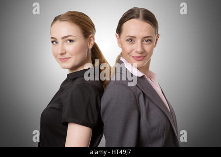 zwei Geschäftsmodelle stehen mit dem Rücken zusammen.  Isoliert auf weiss Stockfoto