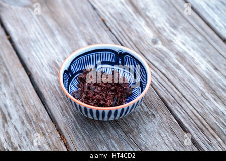 Südafrikanische Rindfleisch Biltong, Wurst in ein blau-weiß gemusterte Schüssel auf einem rustikalen Holztisch. Stockfoto