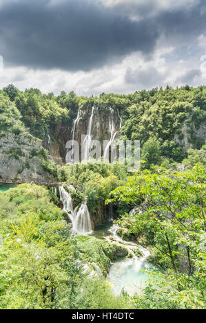 Gewitterwolken bewegen Sie über die vielen Wasserfälle und Karsterscheinungen in Kroatien Nationalpark Plitvicer Seen, während Touristen die Gehwege zu packen. Stockfoto