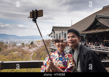 Ein junges Paar Touristen im Kimono, japanische Tracht unter Selfie mit Selfie Stick in Kiyomizu-Dera, buddhistischer Tempel in Kyoto, Japan Stockfoto