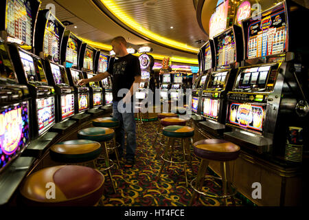 Mann stand vor einer Slot-Maschine in der Kreuzfahrt Norwegen. Kreuzfahrt Norwegen ist ein Unternehmen, das bietet atemberaubende Kreuzfahrten, norwegische Fjorde und Stockfoto