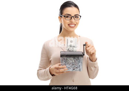 Junge Frau, die eine-Dollar-Banknote in einen Aktenvernichter isoliert auf weißem Hintergrund zu zerstören Stockfoto