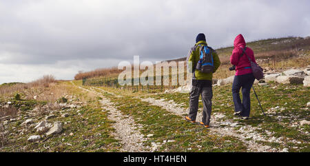 Mann und Frau Wanderer, trekking in Bergen. Junges Paar mit Rucksäcken in Bergen wandern. Stockfoto