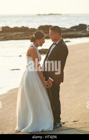 Glücklich verheiratet paar Lachen im Sonnenuntergang Strandzeit. Hispanische paar am Tag der Hochzeit Stockfoto