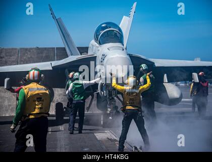 US-Segler bereiten ein Kampfflugzeug der US Navy F/A-18F Super Hornet für den Start aus dem Flugdeck an Bord der USN Nimitz-Klasse-Flugzeugträger USS Carl Vinson 22. Februar 2017 in das Südchinesische Meer. Stockfoto