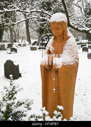 Grabdenkmäler in einem norwegischen Friedhof in der Hauptstadt Oslo, malerischen, friedlichen und ruhigen Madonna an einem verschneiten Wintertag Stockfoto