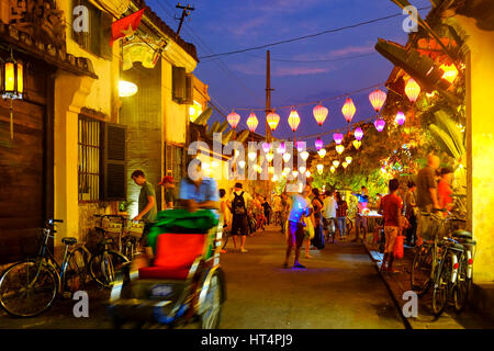 Einheimische und Touristen in Tran Phu Street in der Nacht, Hoi an, Vietnam Stockfoto