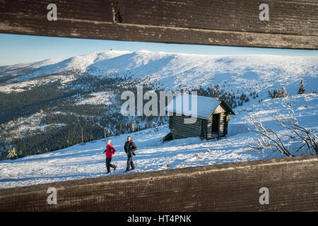 Szklarska Poreba, Polen - Februar 2017: Menschen, die zu Fuß in Richtung kleine Holzhütte am Hang des Szrenica Berg in Szklarska Poreba, Polen Stockfoto