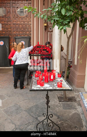 Menschen, die roten Kerzen auf dem Hof der Kirche von San Antonio Abad, Sevilla, Spanien Stockfoto