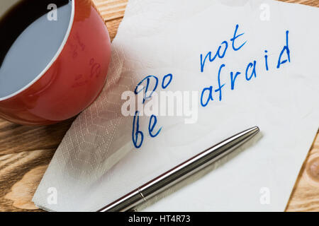 Kaffee Tasse Kugelschreiber und Serviette mit Worten auf hölzernen Tisch Stockfoto