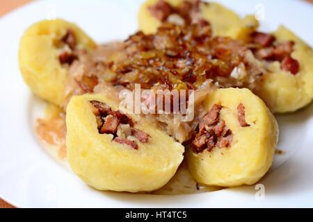 Teil der geschnittenen traditionelle tschechische Kartoffelknödel gefüllt mit geräuchertem Fleisch, geschmortem Kohl und gebratenen Zwiebeln. Stockfoto