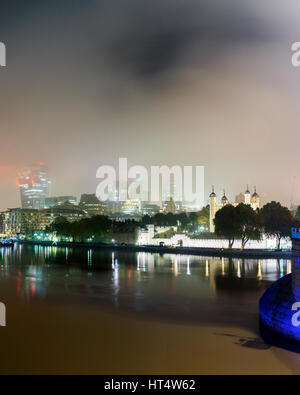 Themse und die Skyline der Stadt im Nebel in der Nacht, London UK Stockfoto