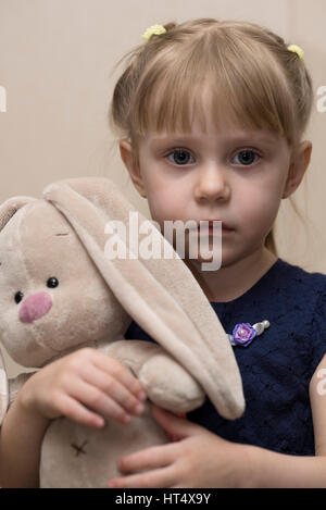 Schöne Mädchen in ihren Händen hält ein Spielzeug-Hase Stockfoto