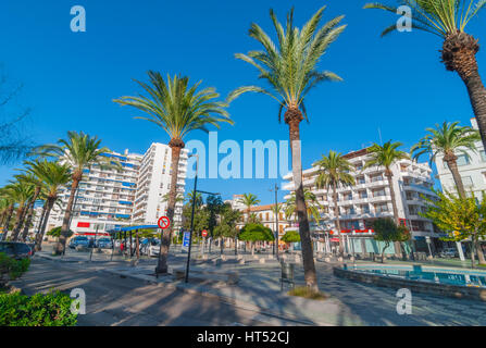 Sant Antoni De Portmany, Ibiza, 6. November 2013: Tourismus in Spanien.  Menschen warten auf ein Taxi-Stand.  Palm von Bäumen gesäumten Fußgänger Park & Brunnen. Stockfoto