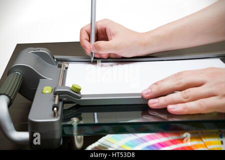 Mann arbeitet auf der Guillotine für Papier Stockfoto