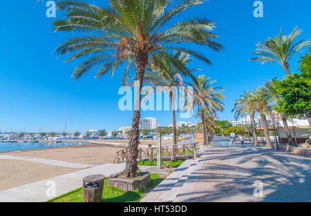 Sant Antoni de Portmany, Ibiza, 6. November 2013.   Bereisen Ibiza bei Sonnenschein.   Die Menschen gehen an wichtigsten Strandpromenade, jetzt eine steinerne Halle neben dem Strand. Stockfoto