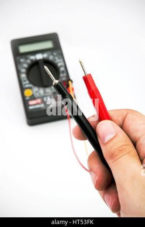 Multimeter mit schwarzen und roten Draht in Händen Stockfoto