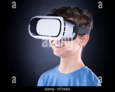 Glücklich teenboy tragen virtual-Reality Brille Filme oder Videospiele spielen. Fröhlich lächelnd Teenager auf der Suche in VR-Brille. Lustiges Kind ex Stockfoto