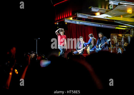 Mick Jagger Schattierung seine Augen von der Strahler auf das Publikum auf der Bühne Gitarre spielen in der Rolling Stones auf der Suche Stockfoto