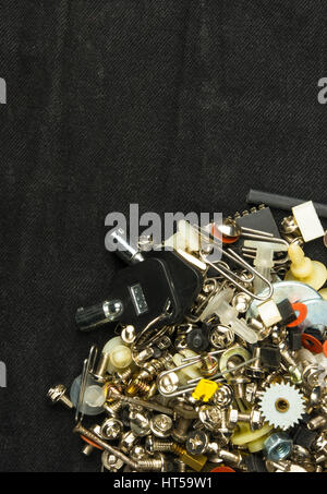 Techno-Hintergründe - verschiedene Schrauben, Schrauben, Unterlegscheiben, Muttern und andere Computer kleine Verbindungselemente auf schwarzem Stoff Stockfoto