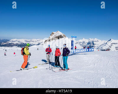 Vier Skifahrer von Piste des Cascades melden Sie sich beim Skifahren auf Schnee Piste hoch in die Berge der französischen Alpen. Flaine, Haute Savoie Rhone-Alpes, Frankreich Stockfoto