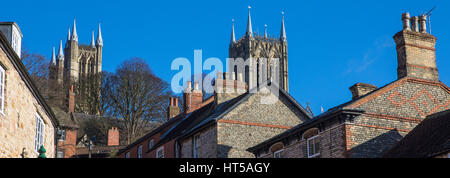 Ein Blick auf die Türme der Kathedrale von Lincoln über die Dächer der Gebäude auf steilen Hügel in der Altstadt von Lincoln, UK. Stockfoto