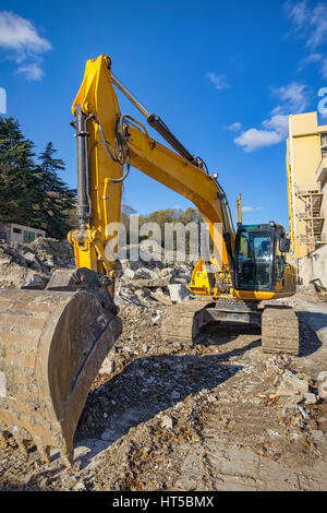 Gelbe Bagger mit Schaufel auf Baustelle. Stockfoto