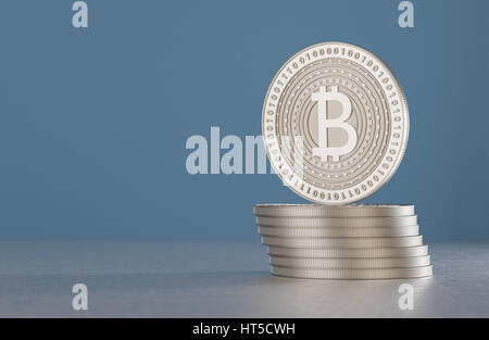 Ein Stapel von Silber Bitcoins auf Metall Boden vor blauem Hintergrund als Beispiel für Krypto Währung Stockfoto