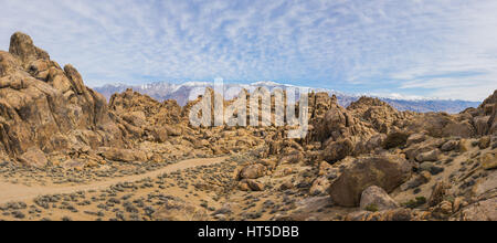 Einsame Schotterstraße schlängelt sich durch die Felsen des kalifornischen Alabama Hills. Stockfoto