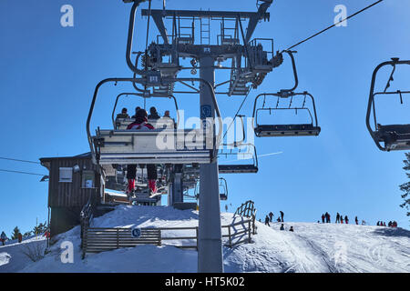 WINTERBERG, Deutschland - 14. Februar 2017: Leute sitzen hoch über die Pisten in einem Sessellift in Ski-Karussell Winterberg Stockfoto