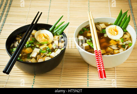 Miso-Suppe in Schalen auf Bambusmatte Stockfoto