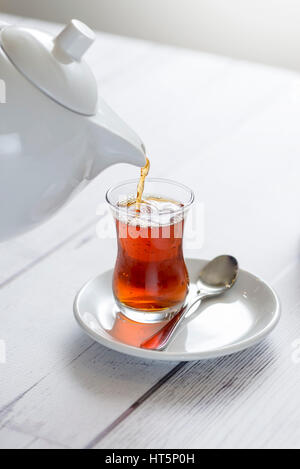 Eine morgendliche Tasse Tee in ein Glas gießen Stockfoto