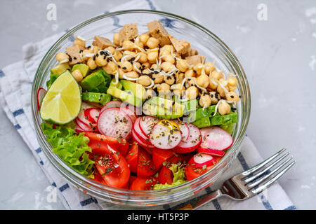 Bunter Gemüsesalat mit Tofu, Kichererbsen, Avocado in eine Glasschüssel. Liebe für eine gesunde vegane Ernährung Konzept Stockfoto